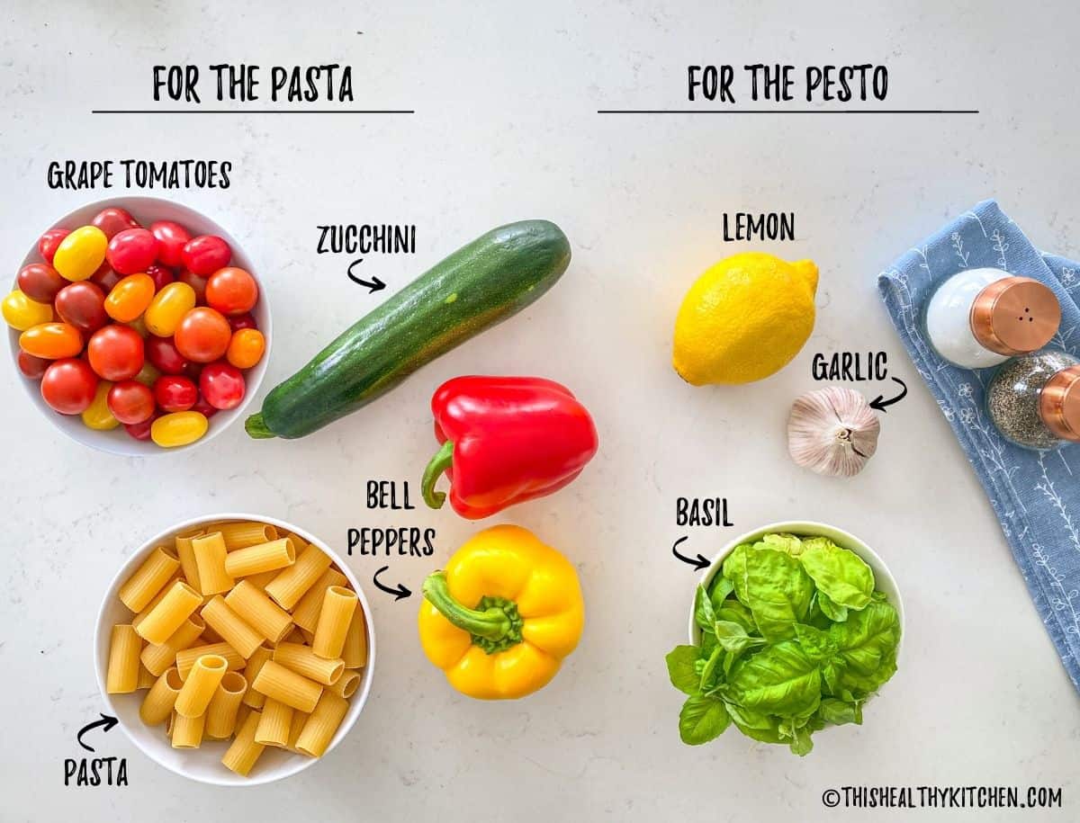 Ingredients needed to make pesto pasta with veggies on kitchen counter.