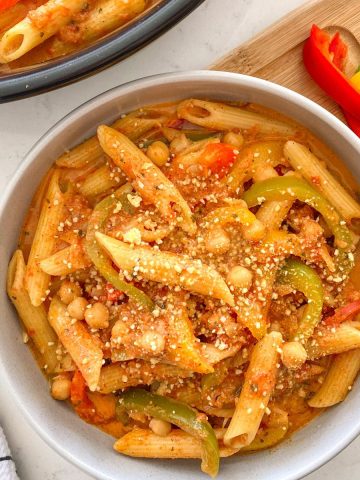 Bowl of pasta with bell peppers and chickpeas inside.