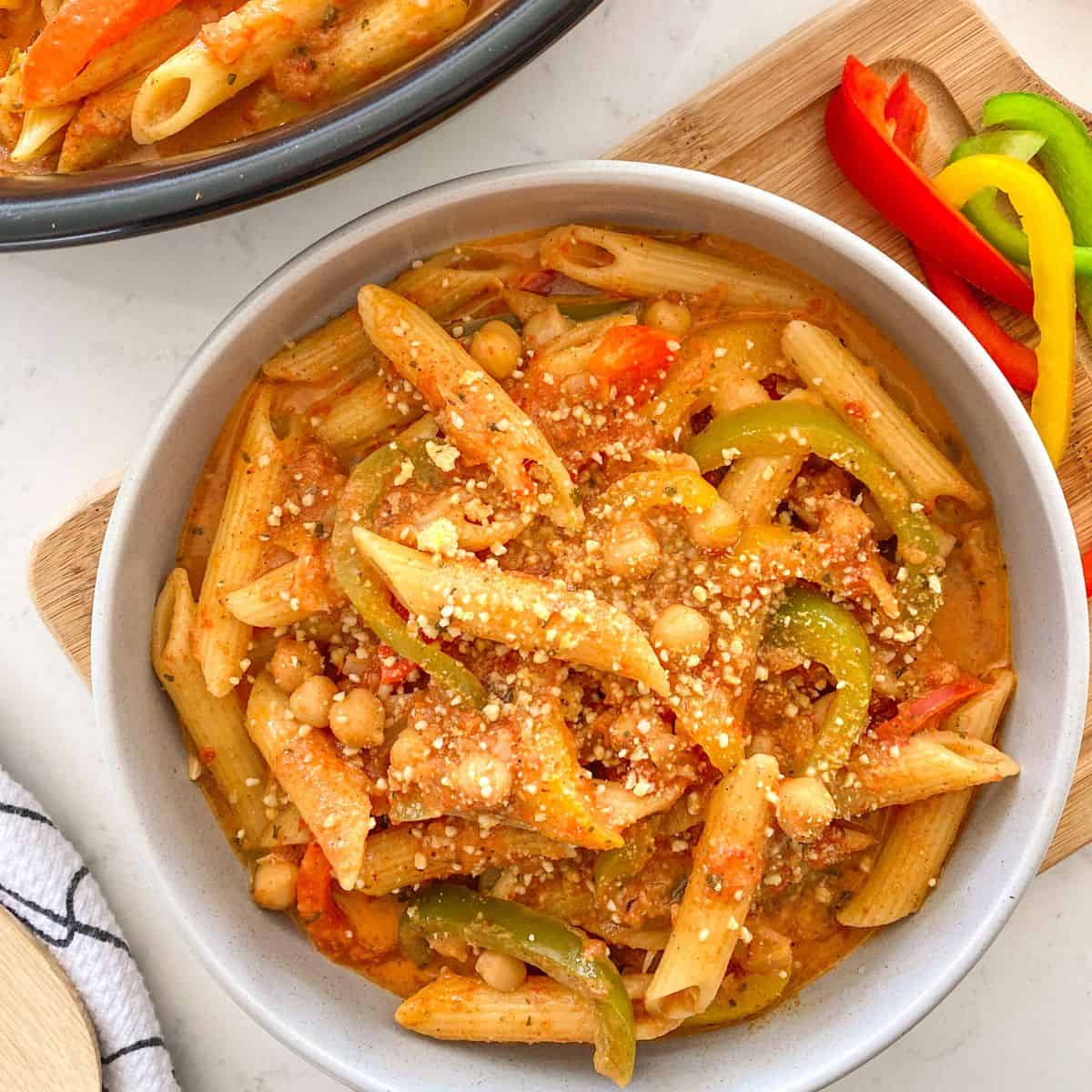 Bowl of pasta with bell peppers and chickpeas inside.