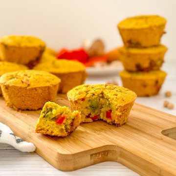 Vegan egg muffin on cutting board with triangle slice cut out.
