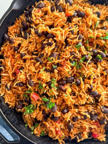 Rice and beans dish inside cast iron pan.