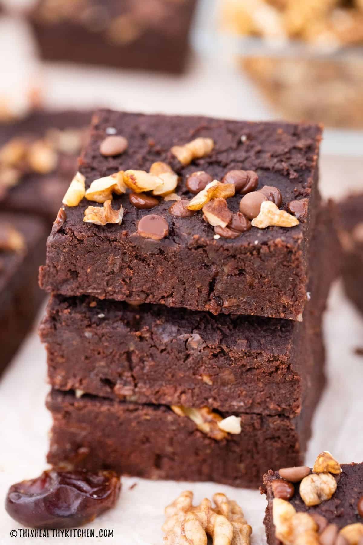 Three vegan brownies stacked on top of each other.