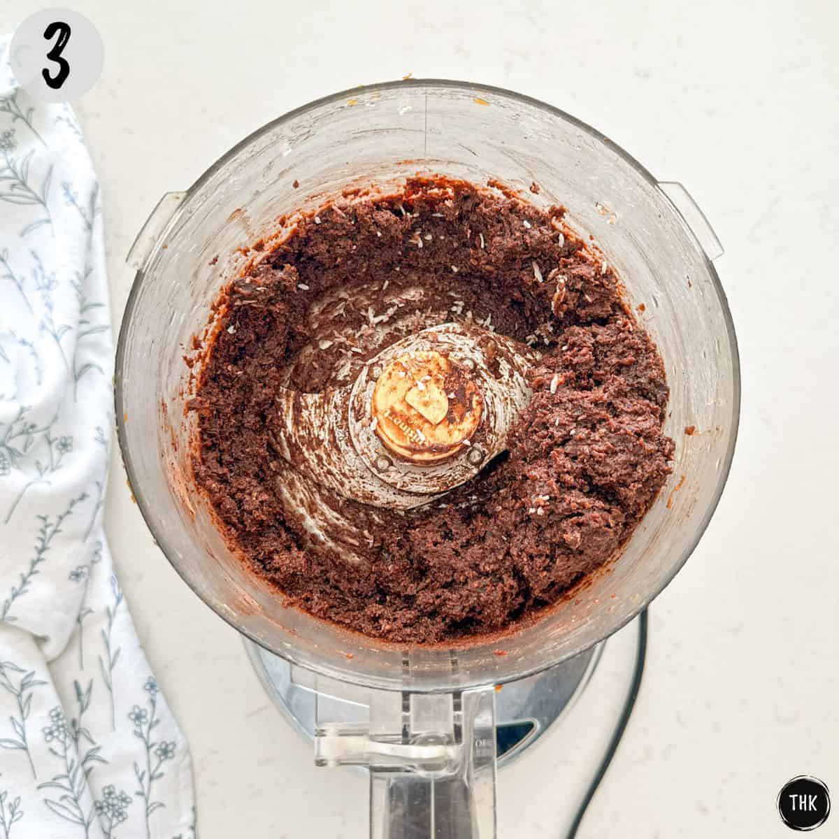 Blended chocolate mixture inside bowl of food processor.