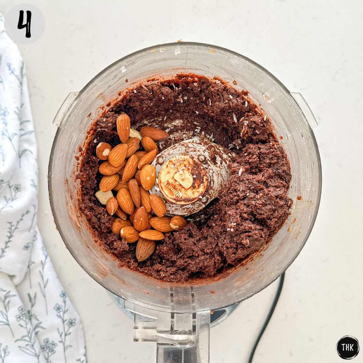 Chocolate almond ball mixture inside food processor bowl.