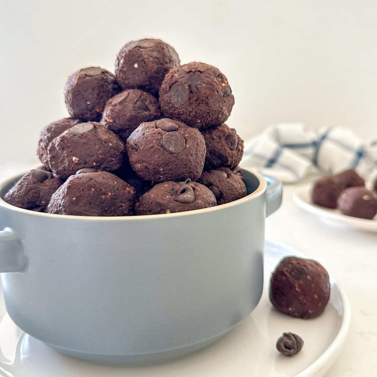 Double chocolate bliss balls stacked inside blue serving bowl.