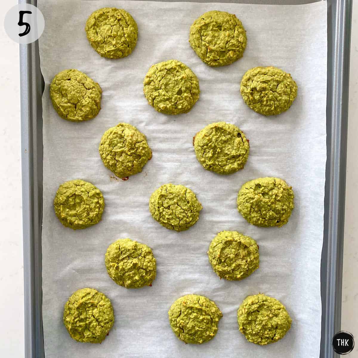 Baked green cookies on baking tray.