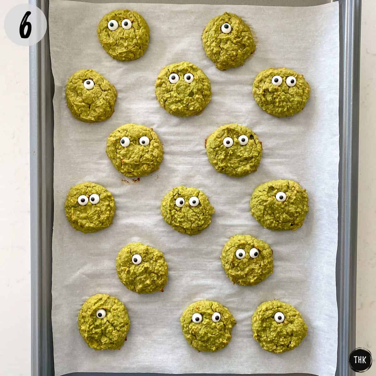 Monster cookies on cookie sheet with candy eyes.