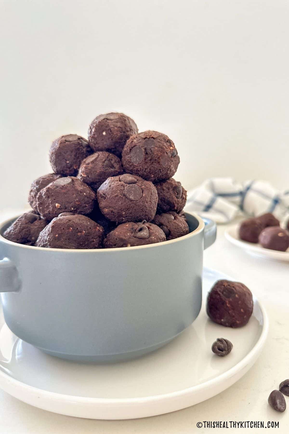 Double chocolate bliss balls stacked inside blue serving bowl.