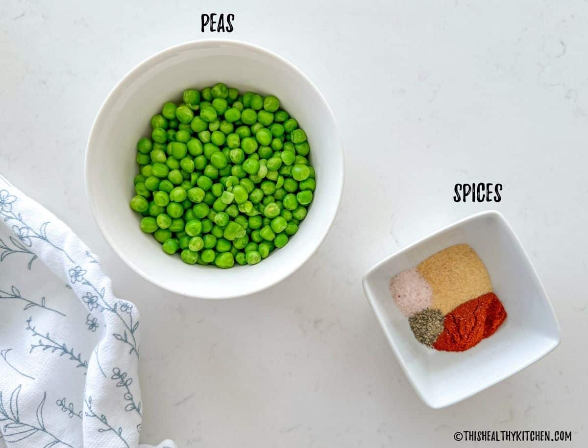 Bowl of peas and bowl of spices on kitchen countertop.
