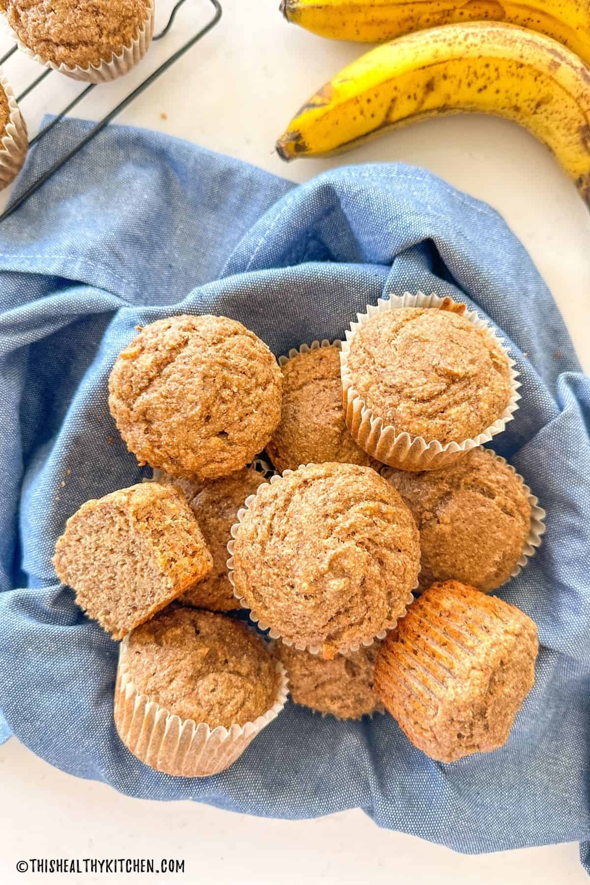 Buckwheat muffins in bowl with blue dish towel below it.