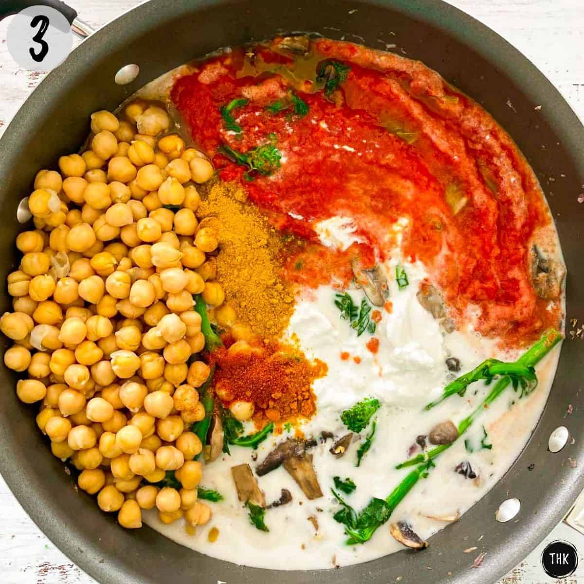 Chickpeas, tomato sauce, curry powder, coconut milk, rapini and mushrooms inside deep pan.