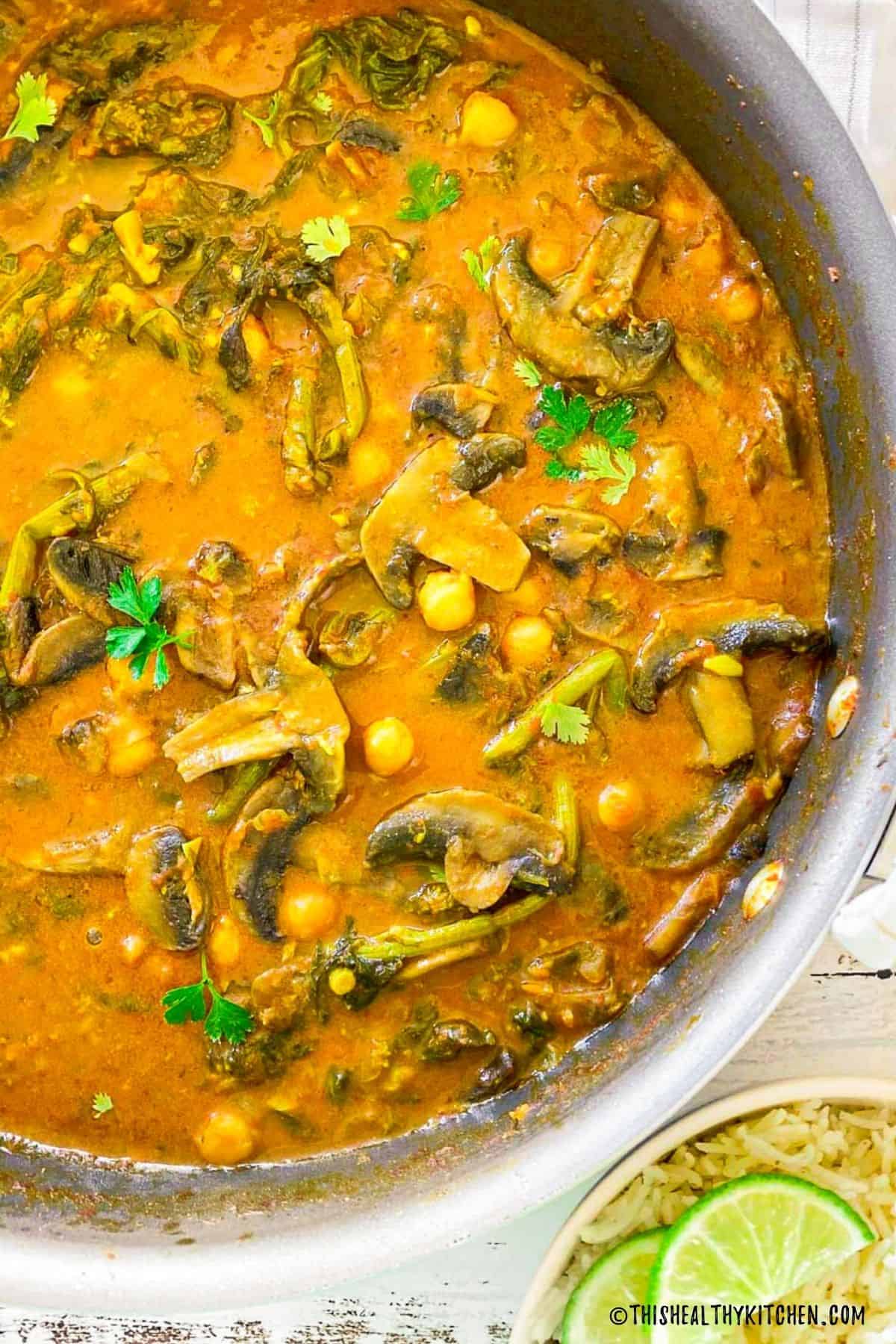 Deep skillet with chickpea mushroom curry inside.