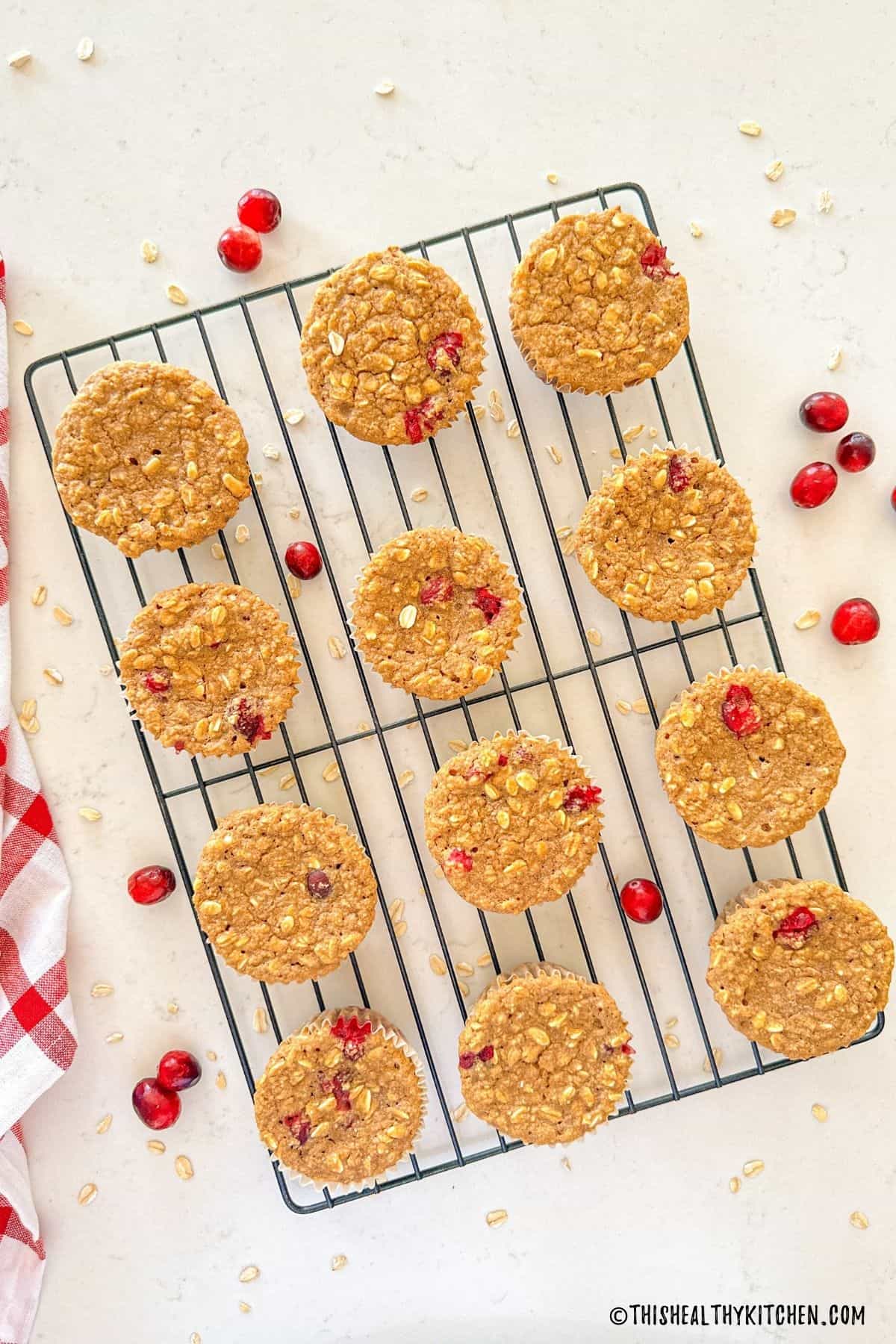 Cranberry muffins on wire rack with fresh cranberries around it.