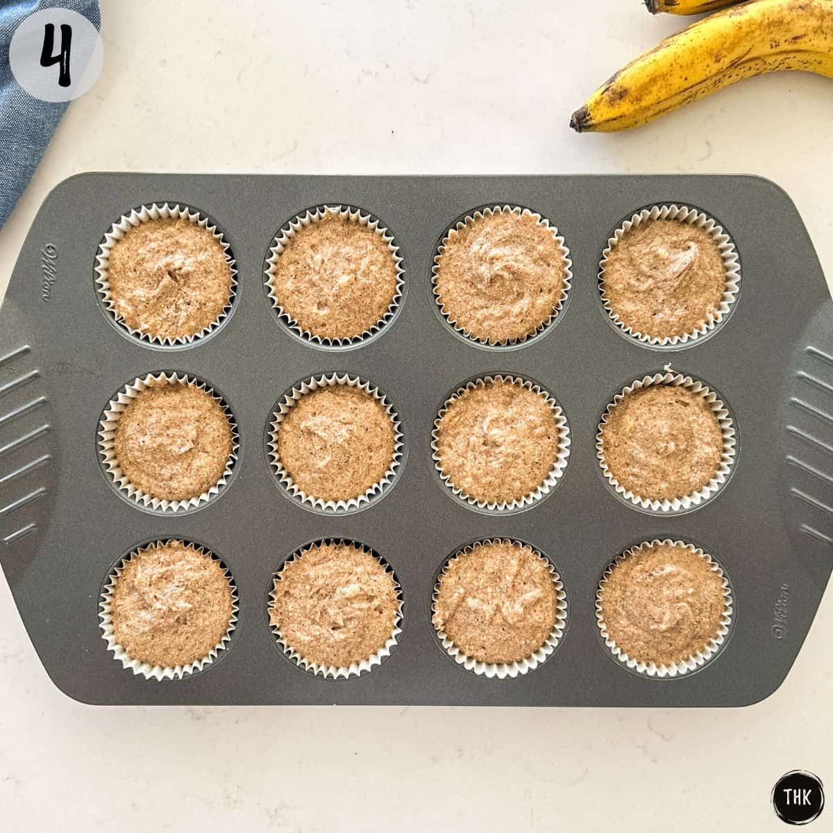 Muffin pan with batter inside before baking them.