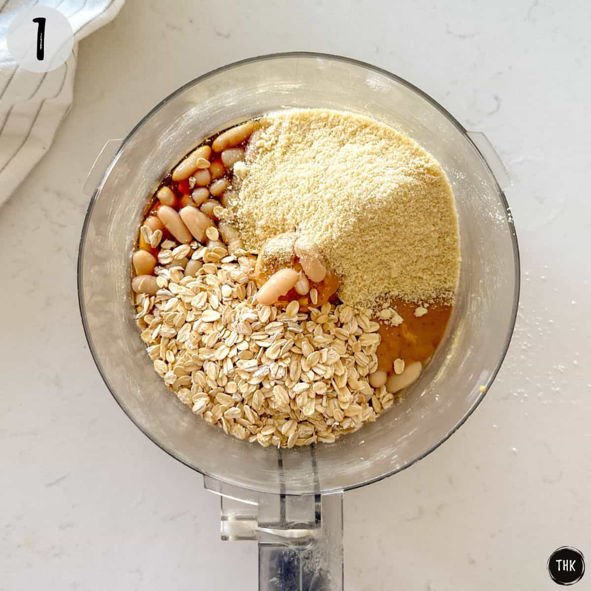 Food processor with oats, white beans, almond flour and peanut butter.