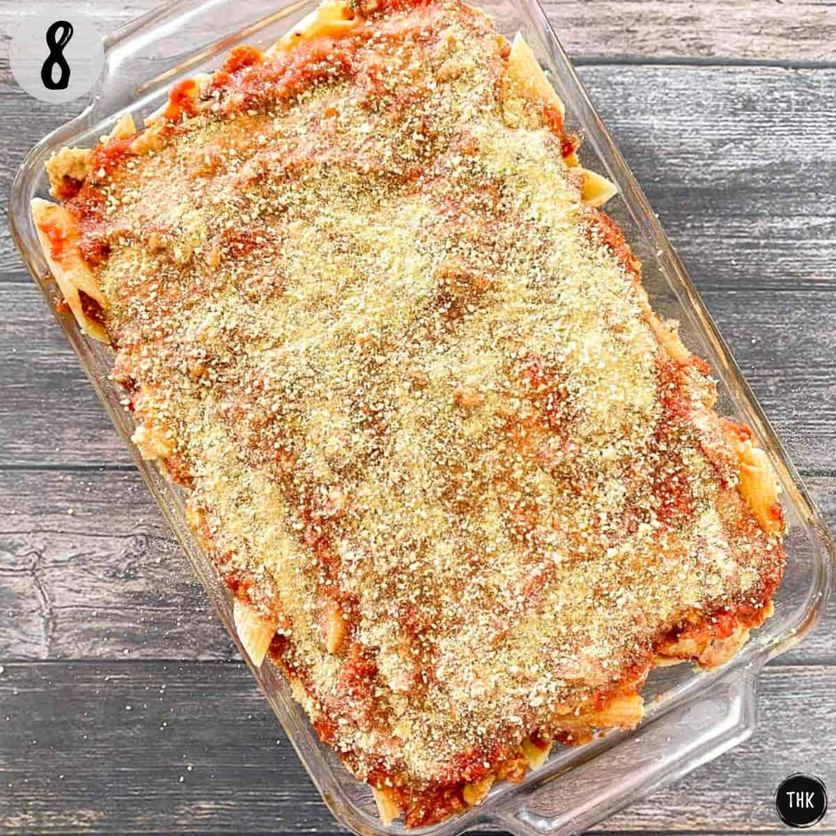 Vegan baked pasta dish in glass tray with parmesan sprinkled on top.