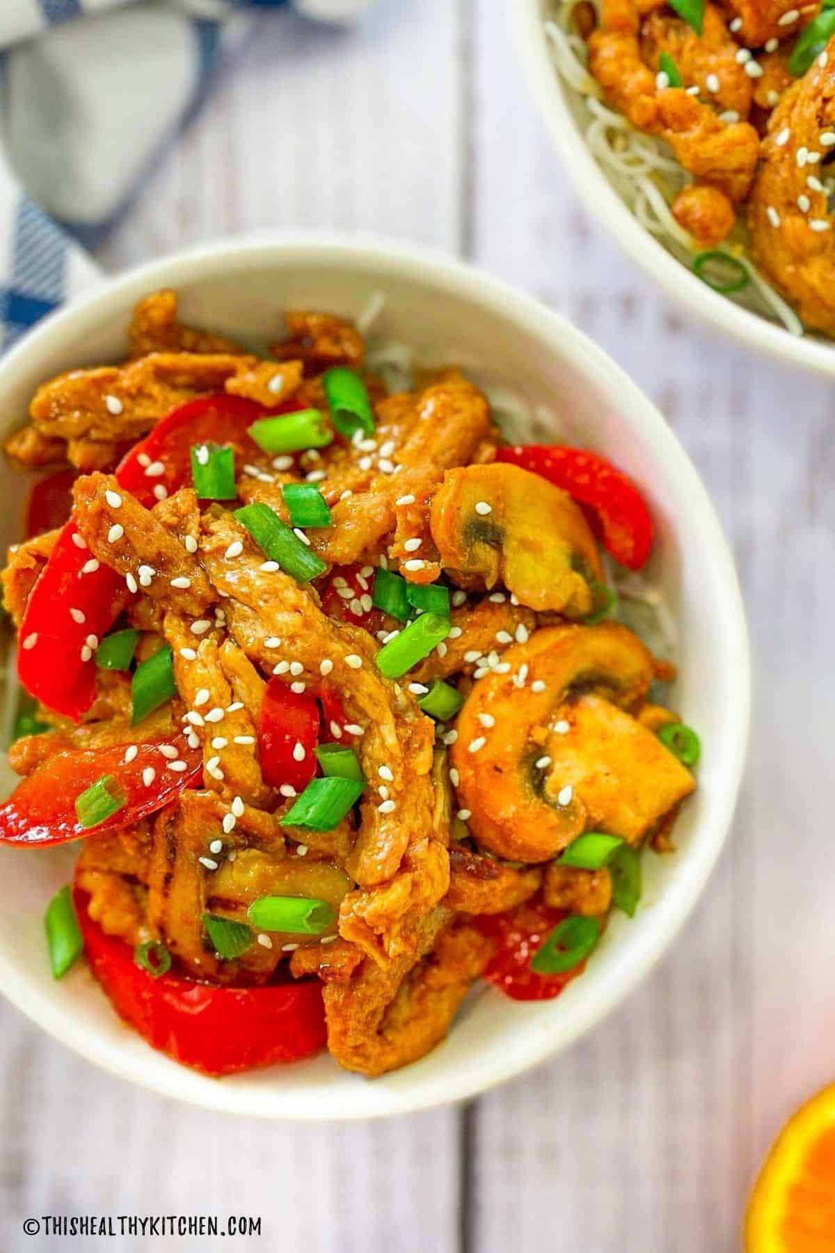 Soy curls with peppers and mushrooms in a white bowl.