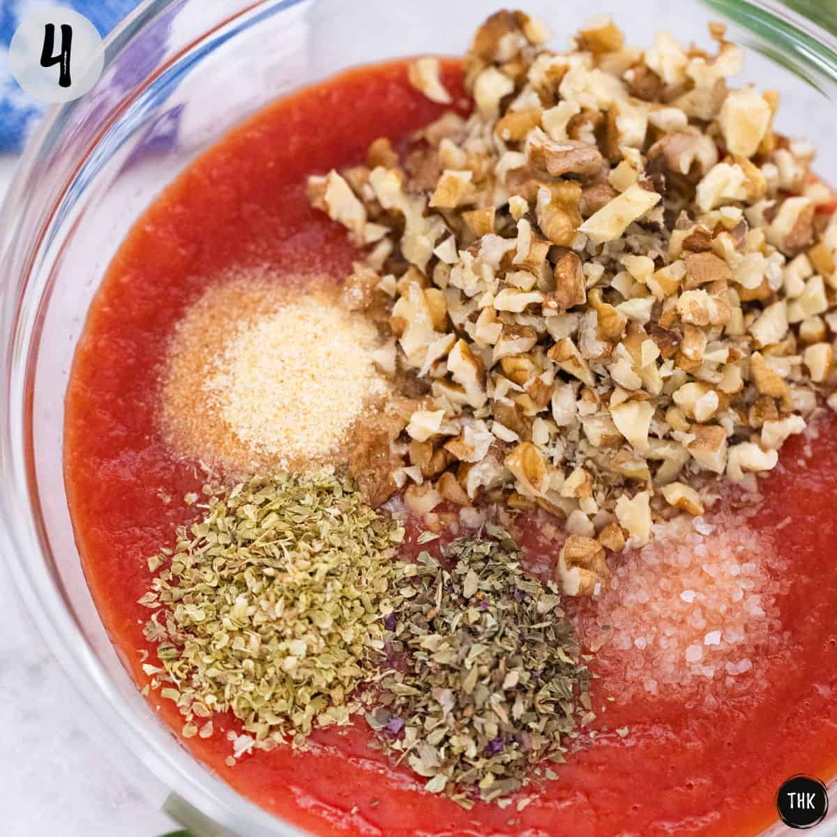 Tomato sauce, spices and chopped walnuts inside glass bowl.