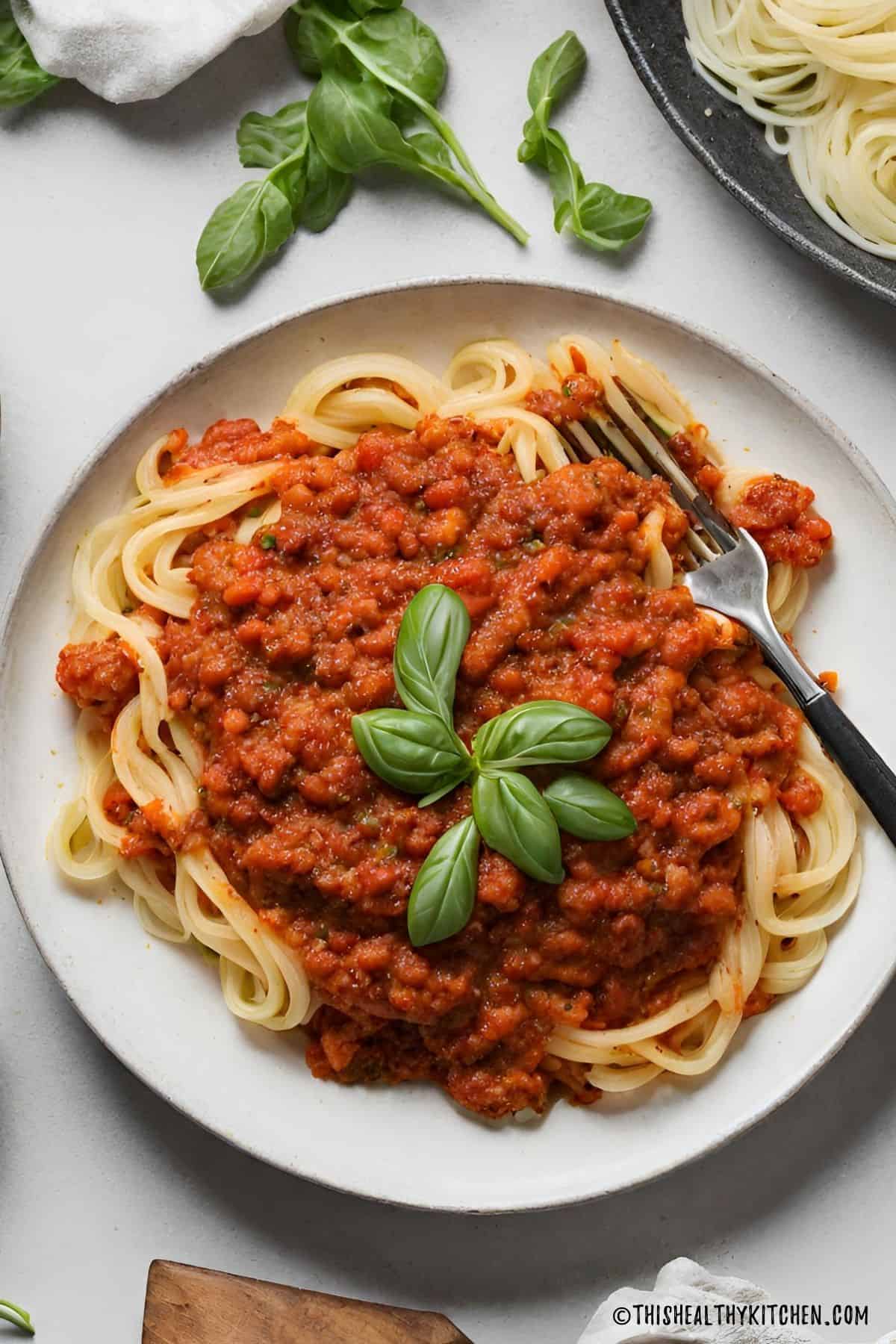Plate of spaghetti with vegan bolognese sauce on top.