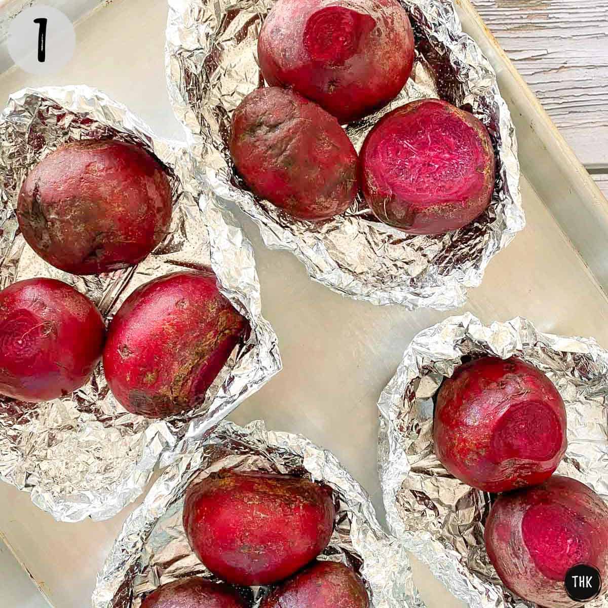 Beets with sliced top sitting in foil packets on baking sheet.