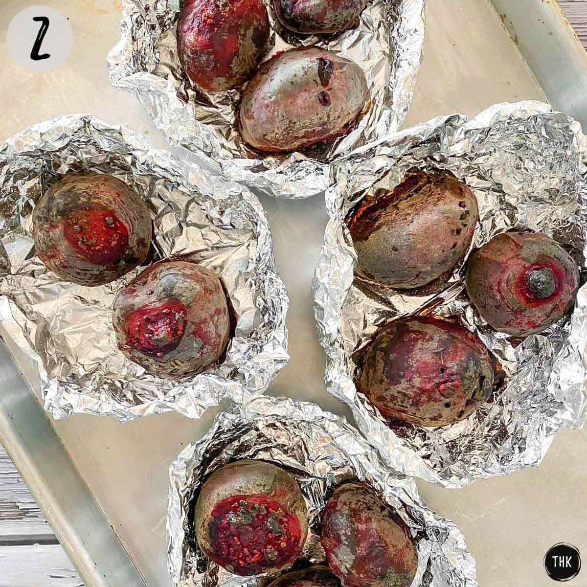 Roasted beets in foil packets on baking sheet.