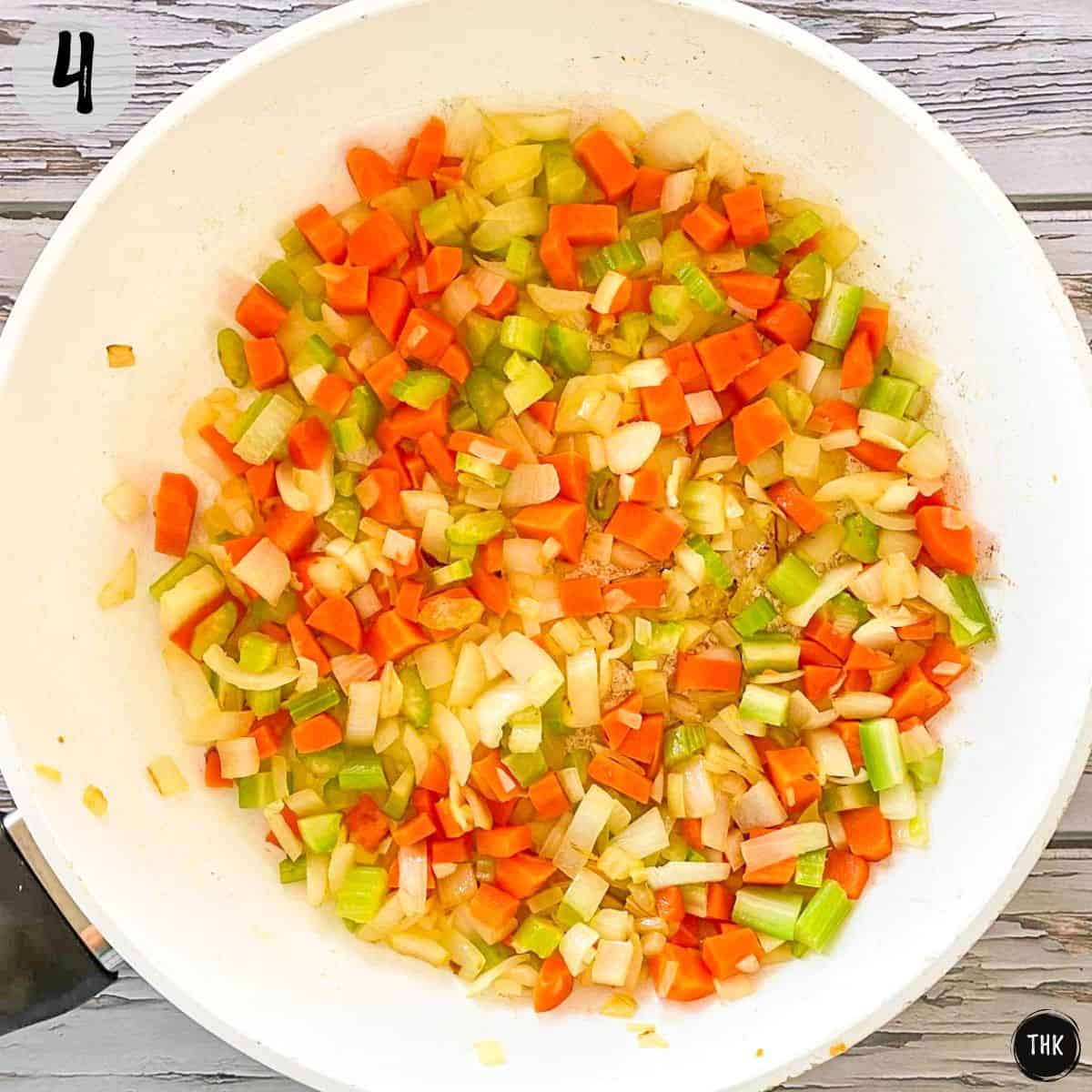 Sautéed onion, carrot and celery in pan.