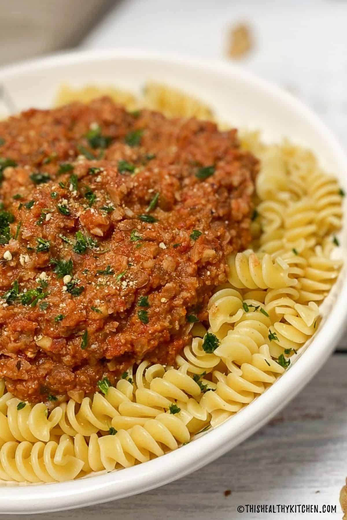 Rotini pasta with cauliflower bolognese sauce on top.