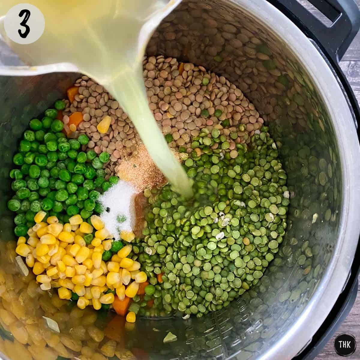 Broth being poured into Instant Pot with lentils, split peas, corn and frozen green peas inside.