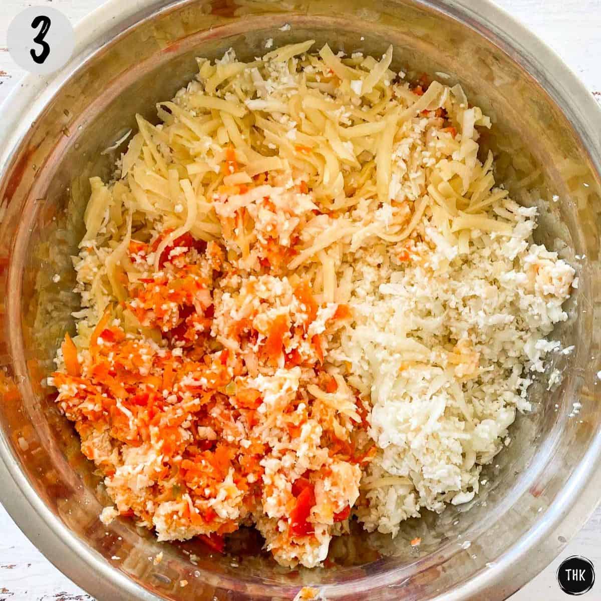Shredded potatoes, cauliflower, sliced peppers and onions inside large mixing bowl.