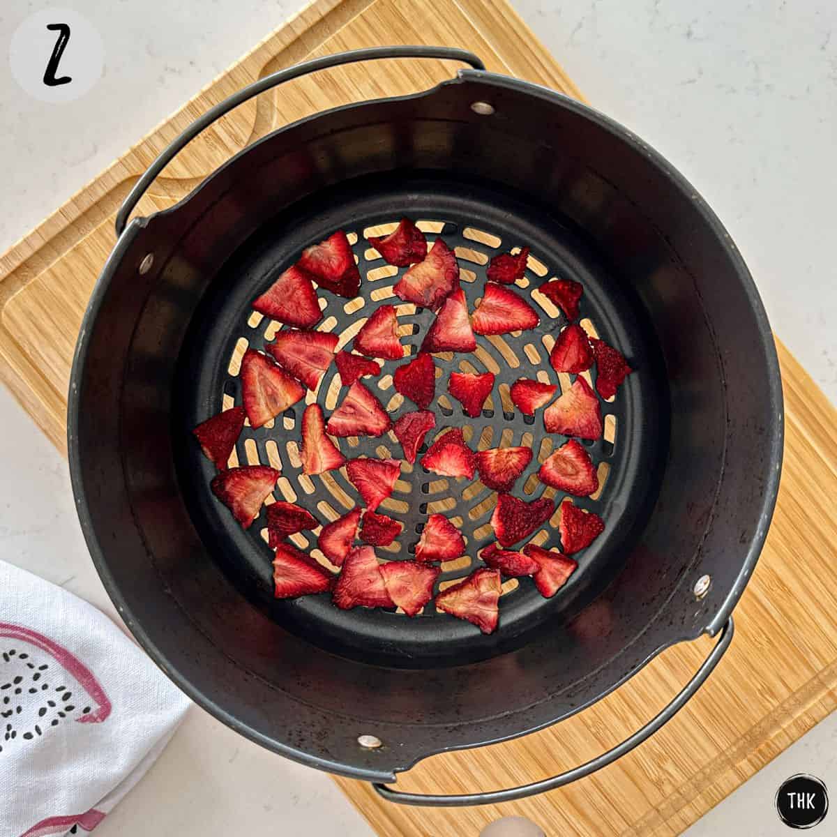 Dehydrated strawberry slices inside air frying basket.