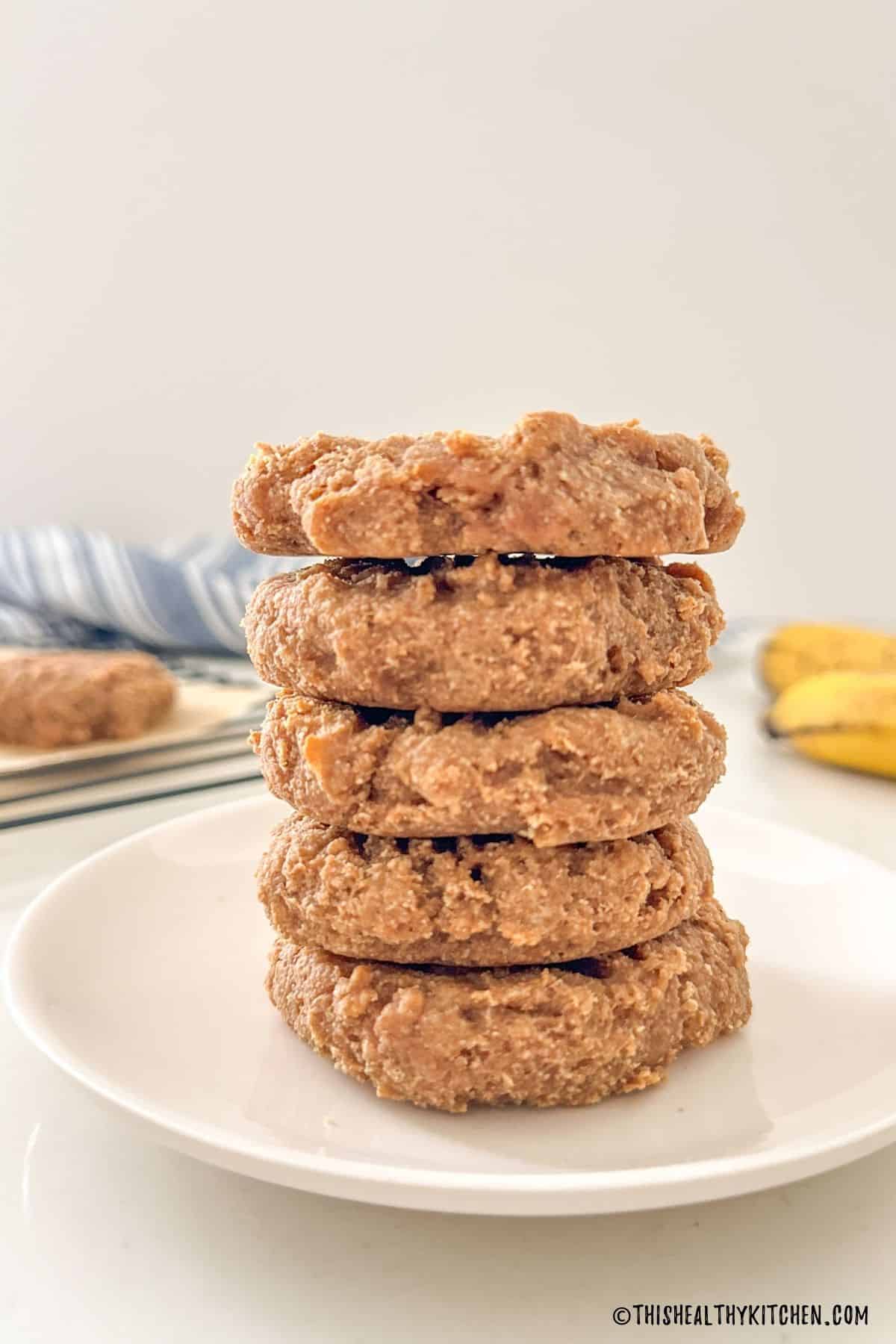 Stack of five vegan protein cookies on plate.