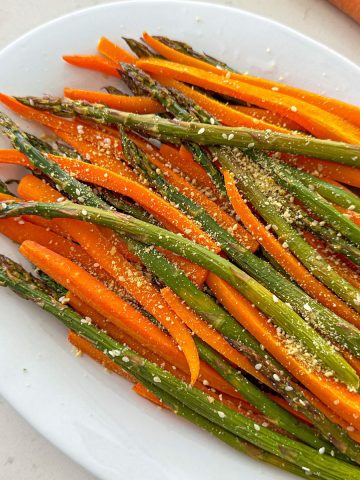 Platter with roasted asparagus and carrots on top.