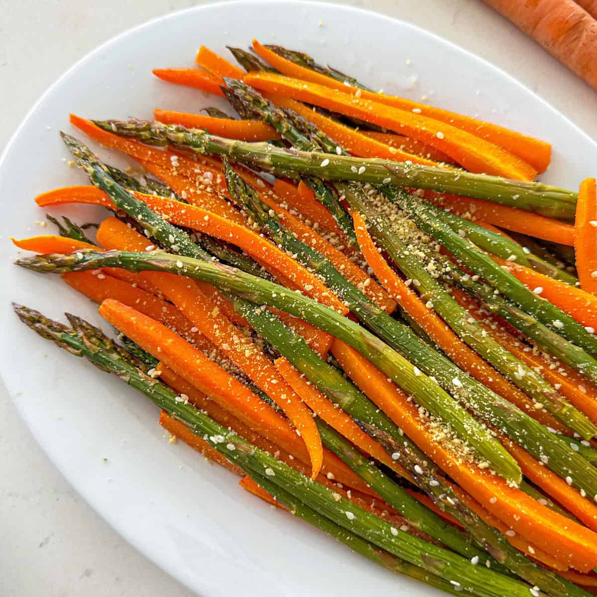 Platter with roasted asparagus and carrots on top.