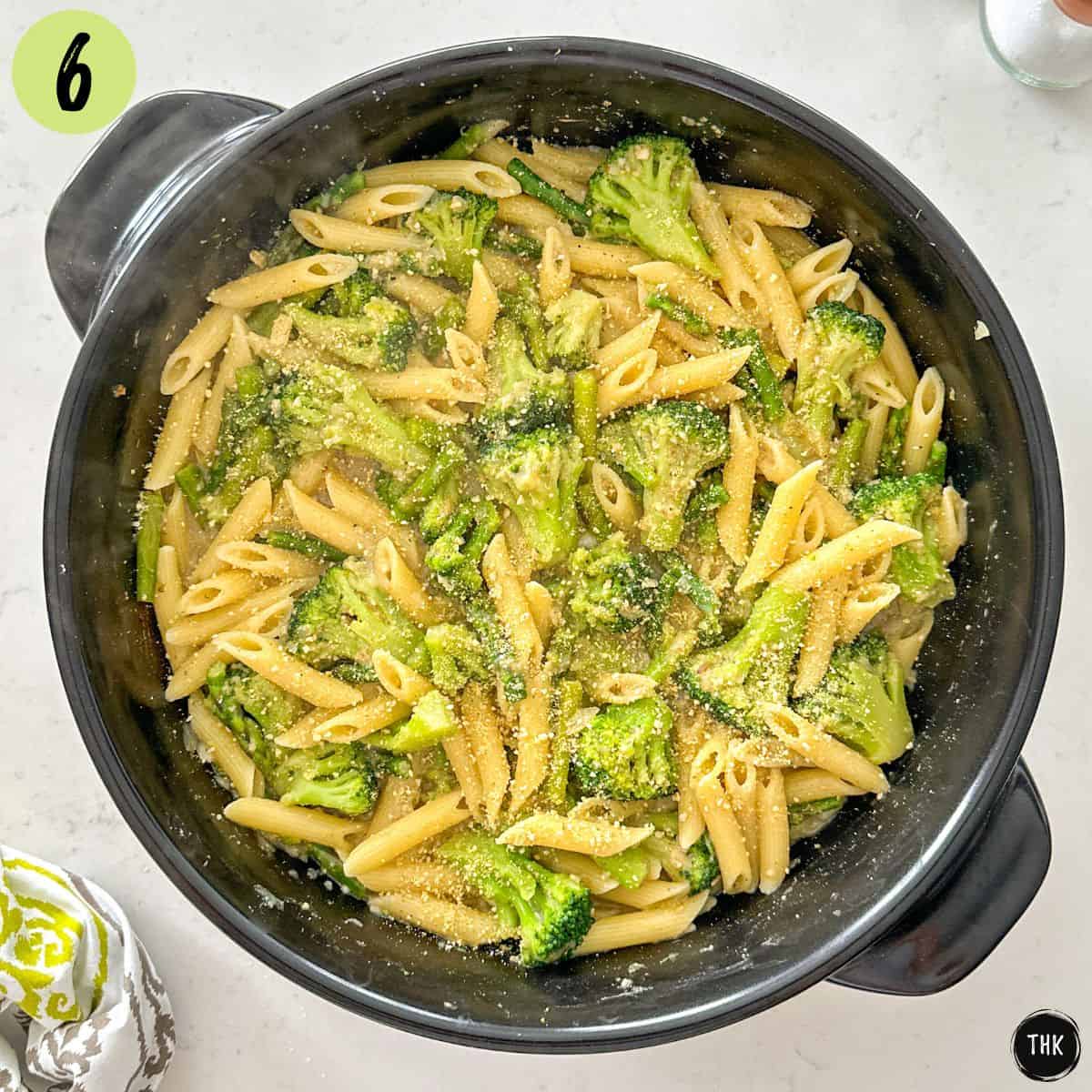 Broccoli asparagus pasta in large skillet with vegan parmesan cheese on top.