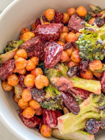 Broccoli and beetroot salad in white bowl.