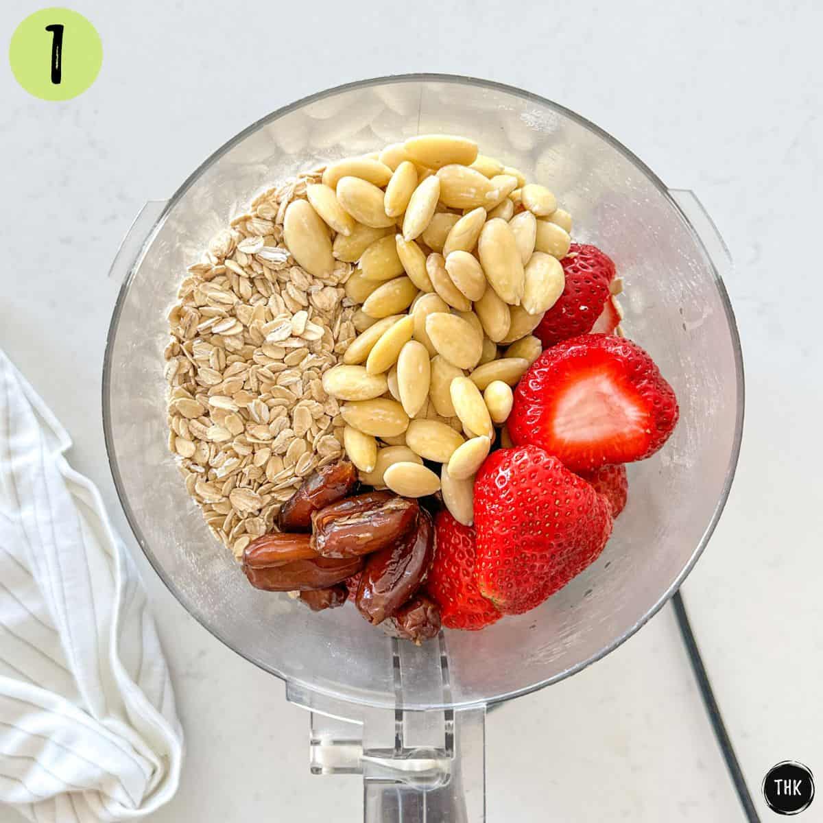 Strawberries, almonds, dates, and oats in food processor bowl.