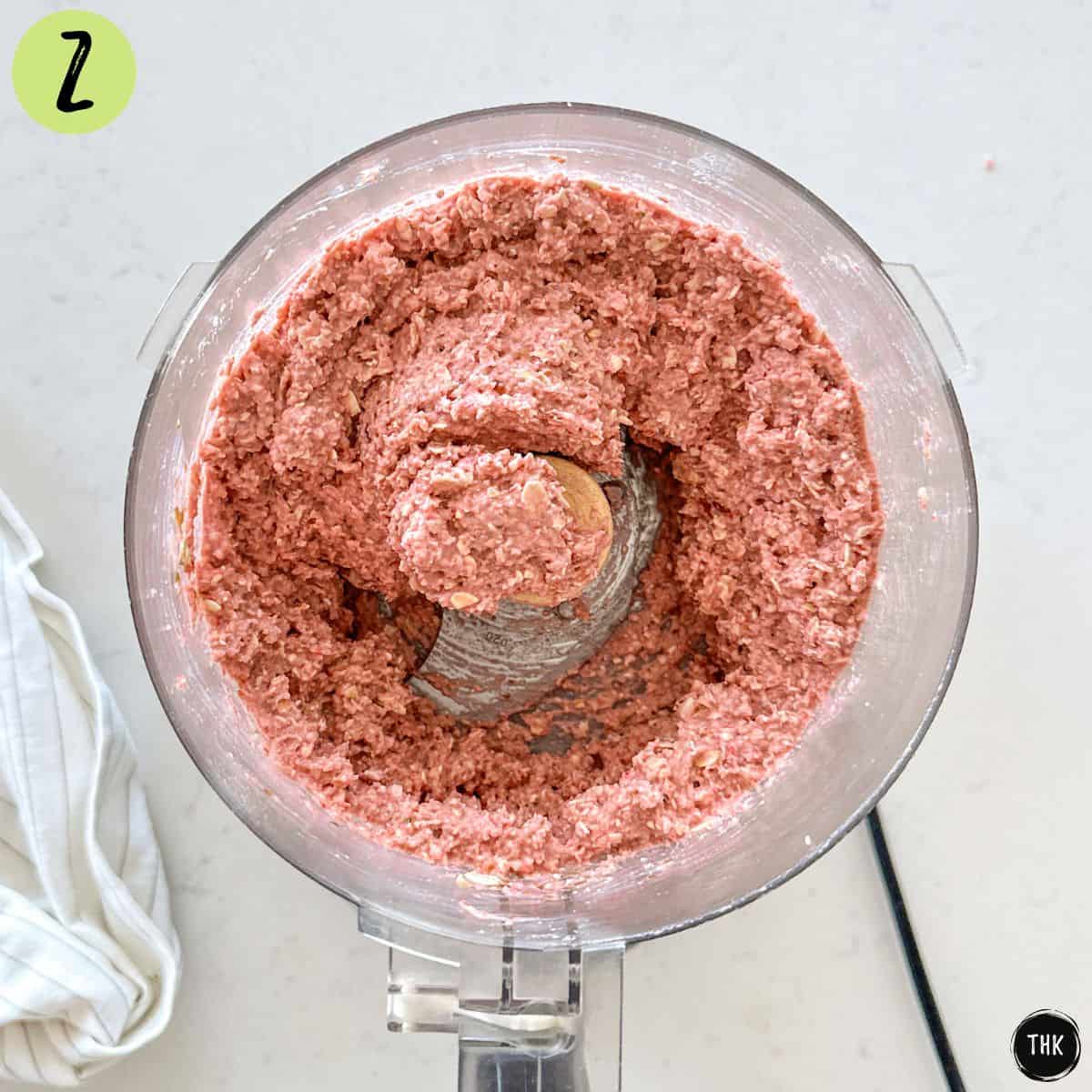 Pink blended mixture inside food processor bowl.