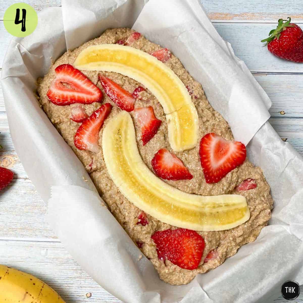 Strawbery slices and banana slices on top of unbaked sweet bread in loaf pan.