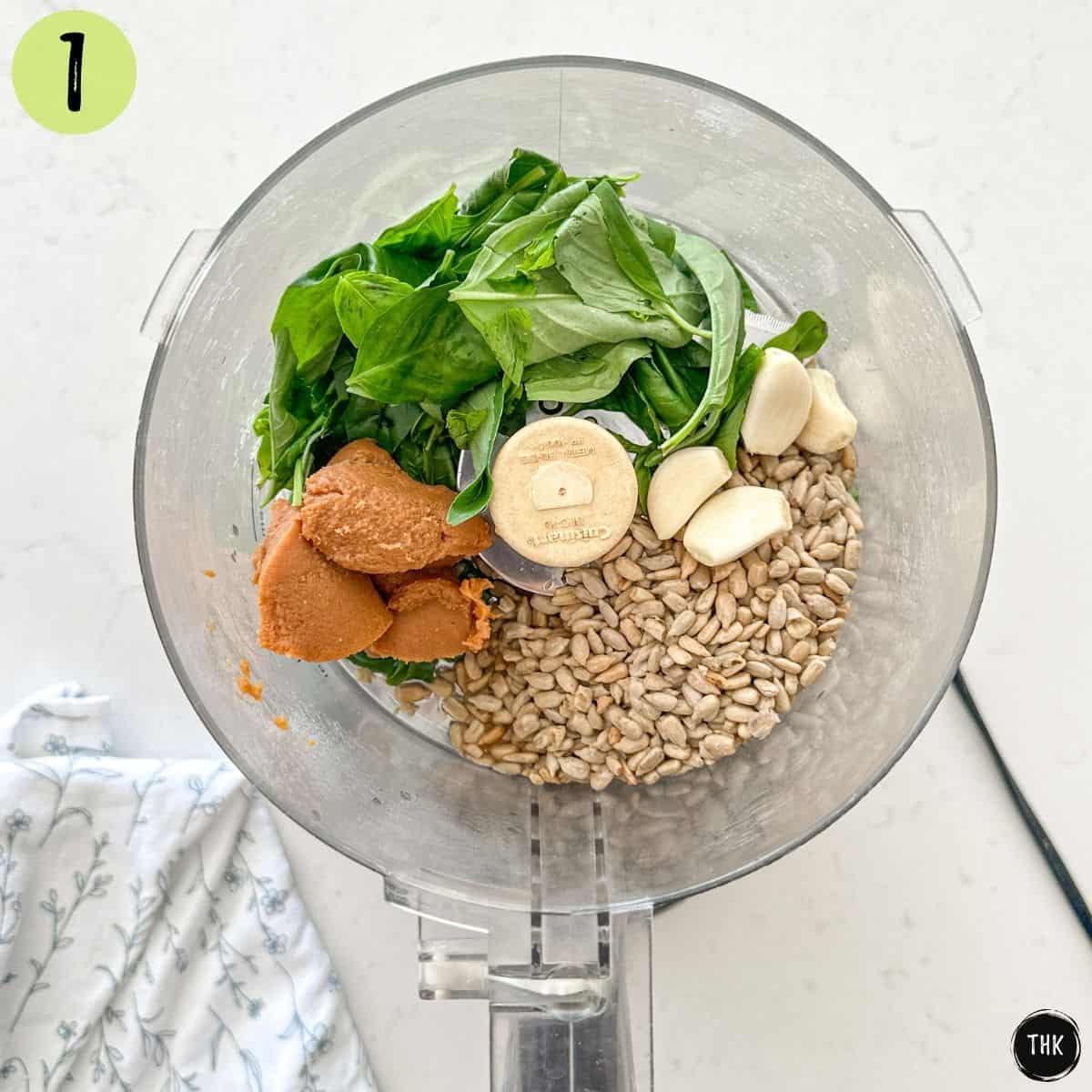 Basil, miso paste, garlic, sunflower seeds and vinegar inside food processor.