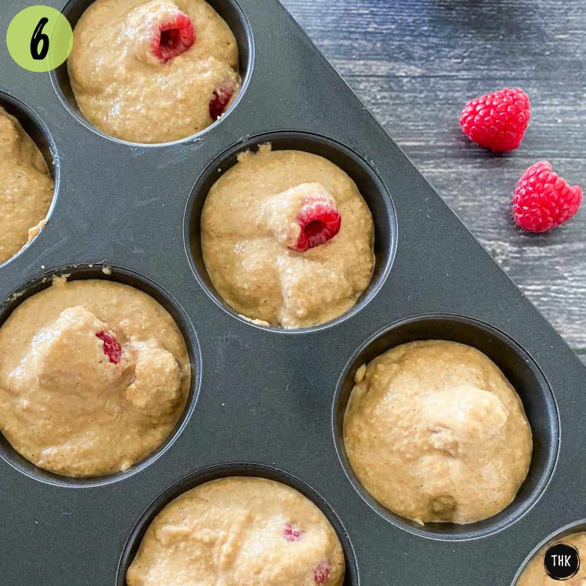Raspberry muffins inside muffin pan before baking.