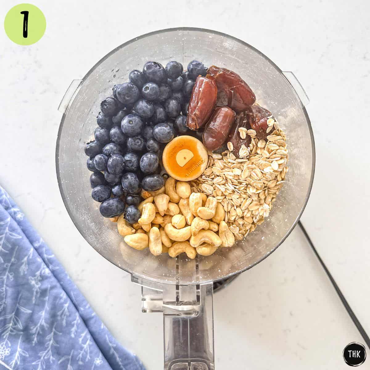 Blueberries, dates, oats, cashews, and vanilla inside food processor.