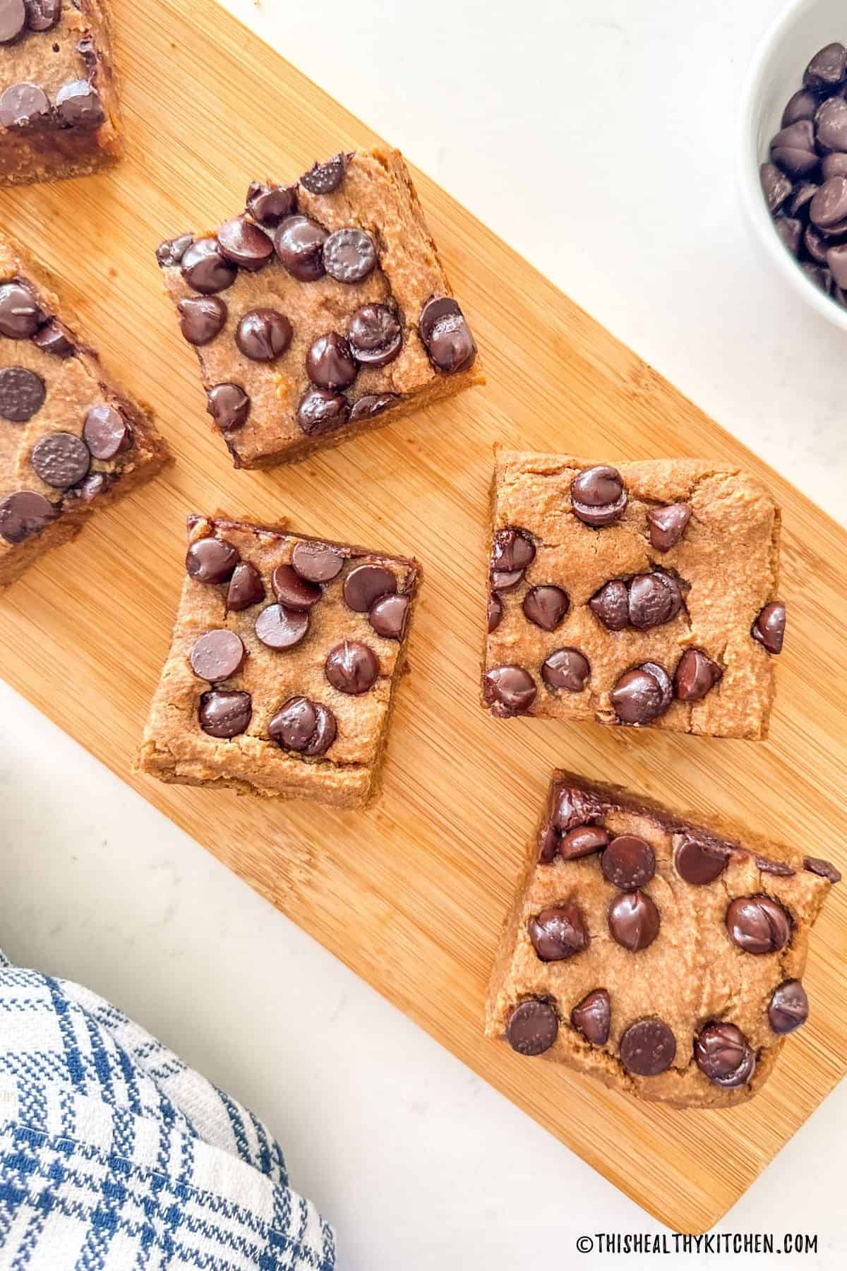 Vegan white bean blondies with chocolate chips on cutting board.
