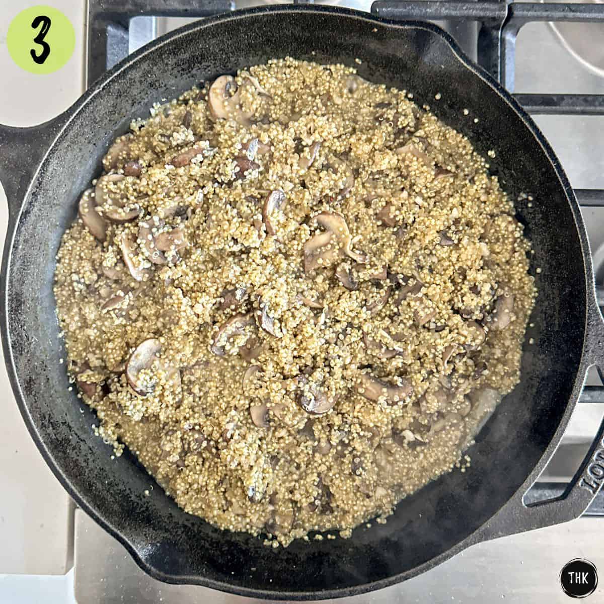 Sauteed mushrooms and garlic in cast iron pan with raw quinoa on top.