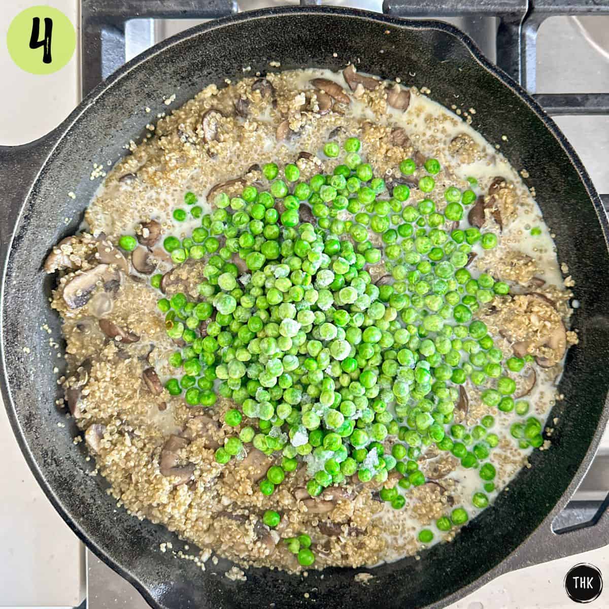 Cooked quinoa and mushrooms inside pan with green peas on top.