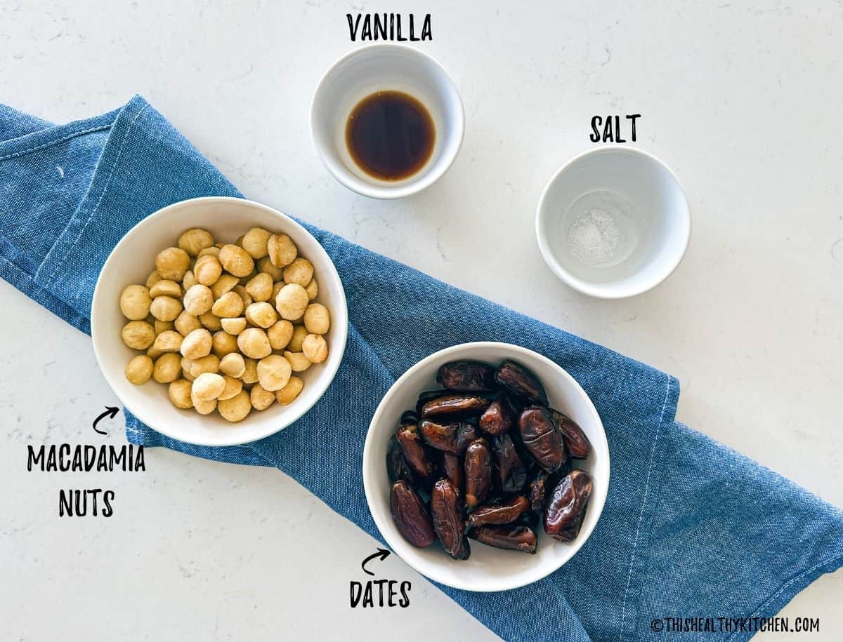 Bowls of macadamia nuts, dates, vanilla and salt on countertop.