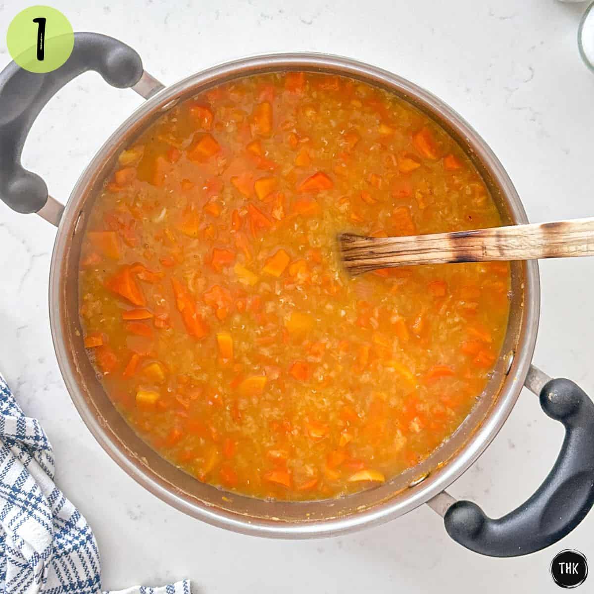 Large pot of soup with carrots, sweet potato, onion, lentils, and broth.