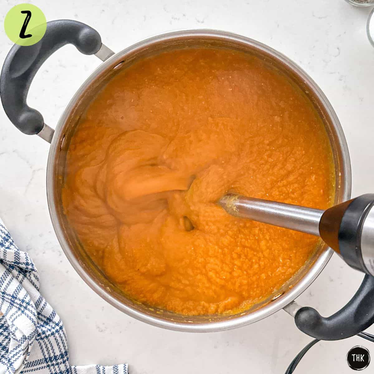 Immersion blender inside pot of soup to puree it.