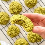 Hand holding up matcha cookie with bite taken out of it.