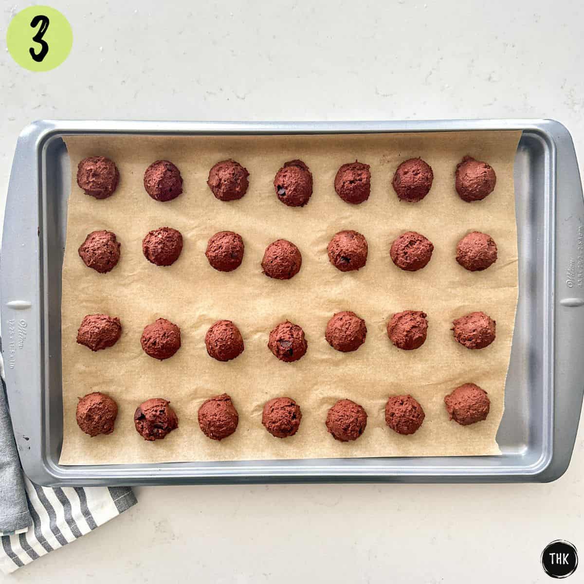 Balls of double chocolate cookie batter on baking sheet.