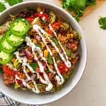 Vegan taco salad with veggies, black beans, and jalapenos on top.